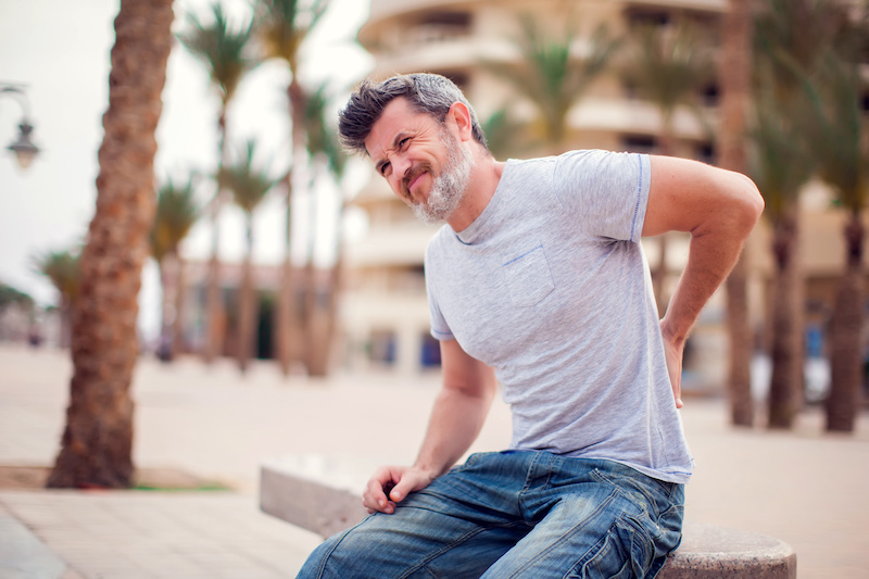 Man experiencing sharp stabbing pain in lower left side of back