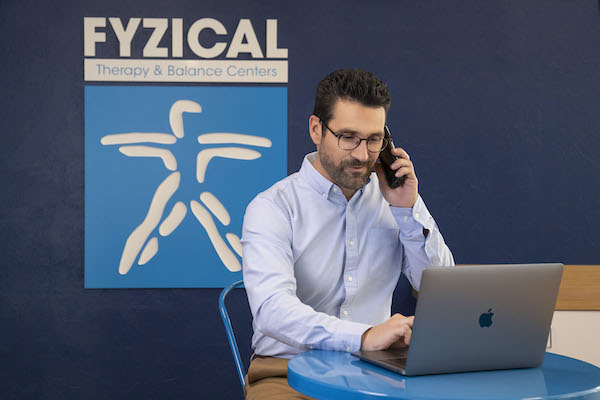 Physical therapist at FYZICAL Therapy & Balance Centers conducting a telehealth physical therapy session with a patient