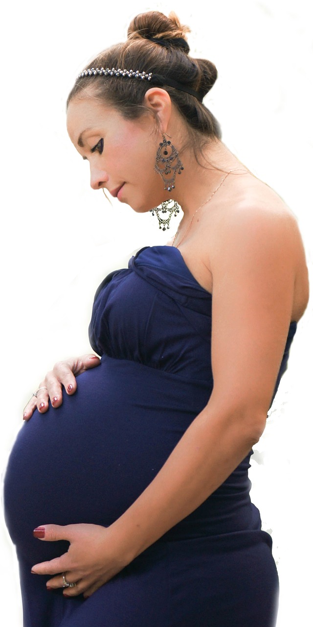 Pregnant woman in a blue dress holding her belly with a contemplative look, reflecting the challenges and anticipation of motherhood.