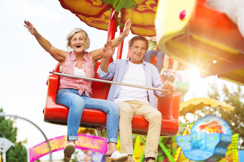 Couple happily enjoying carnival ride after physical therapist cures dizziness symptom